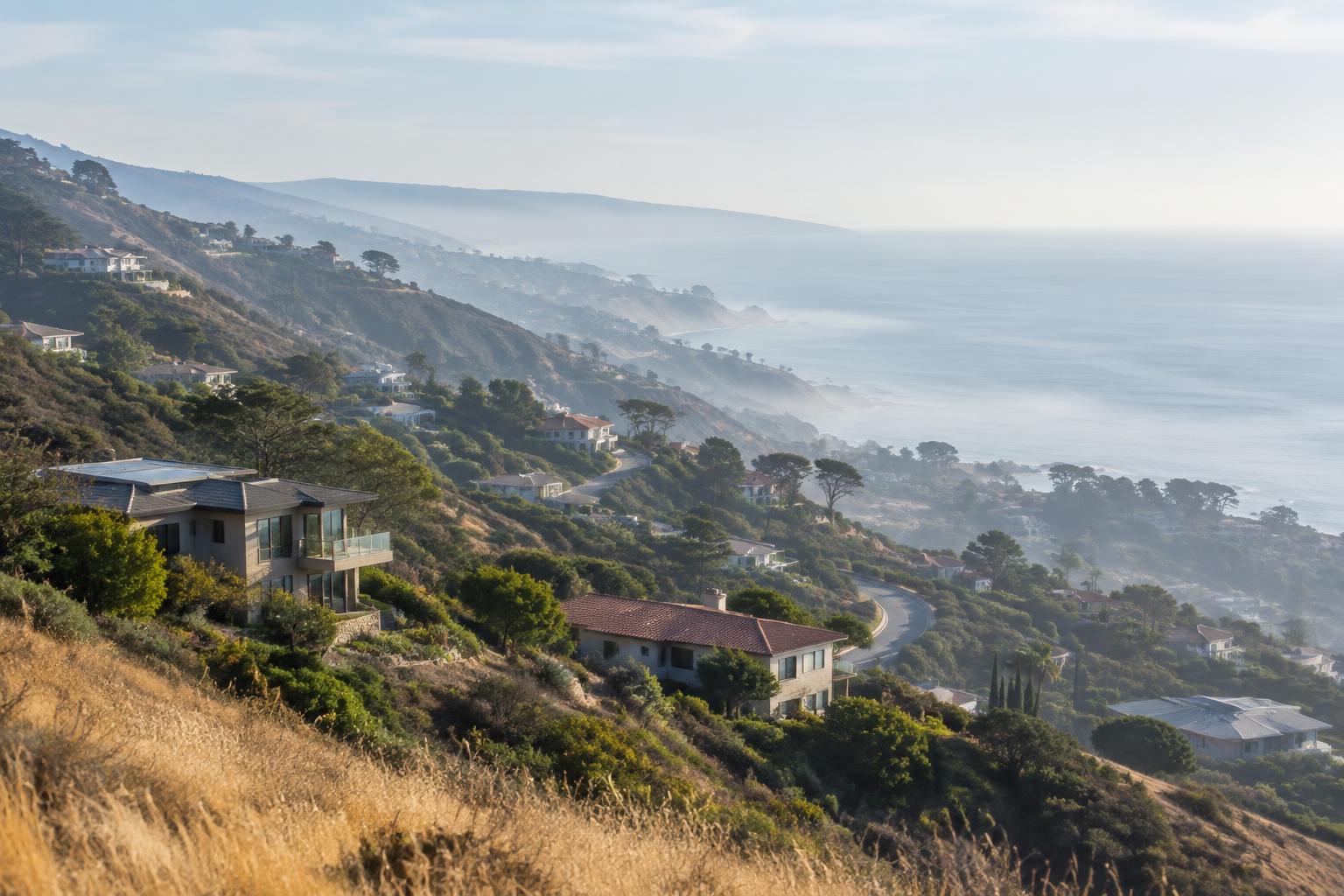 Hillside homes above a hazy stretch of the California coastline